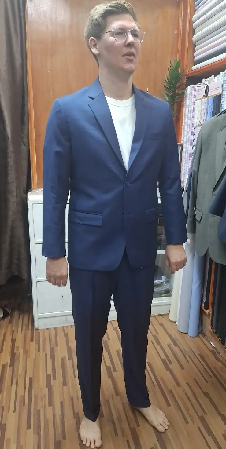 A blue suit at the fitting, worn over a plain tee while the line is checked.
