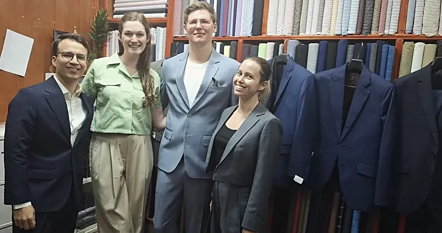 Four made garments together — navy, pale blue and grey tailoring with wide cream trousers.