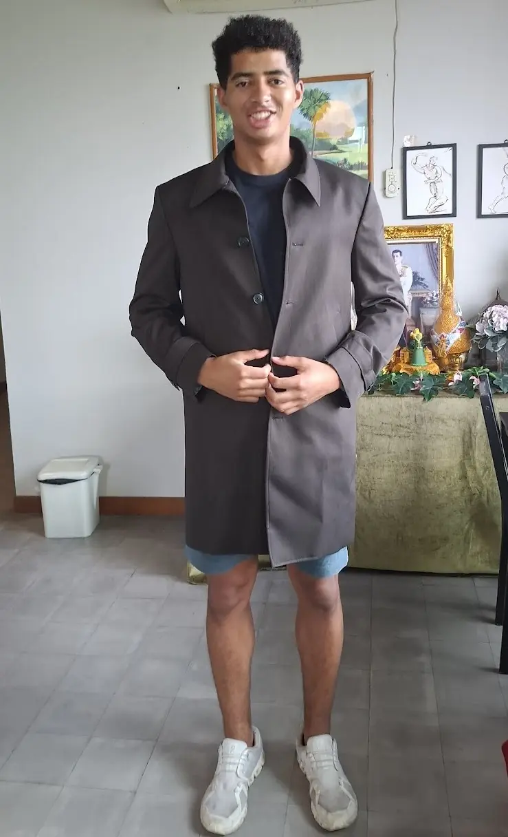 A grey overcoat tried on at home, buttoned to check the front.