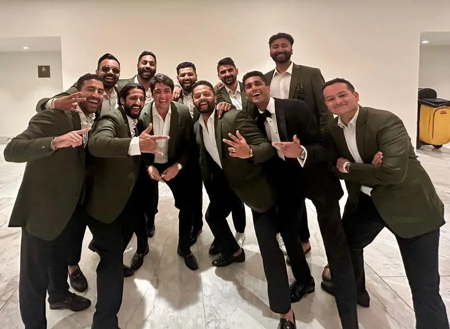 Eleven groomsmen in olive dinner jackets with one in black tie, after the ceremony.