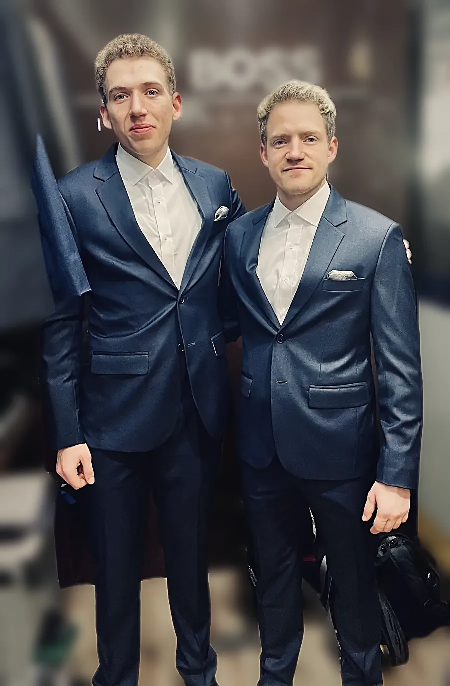Two navy suits with white pocket squares, finished and collected together.