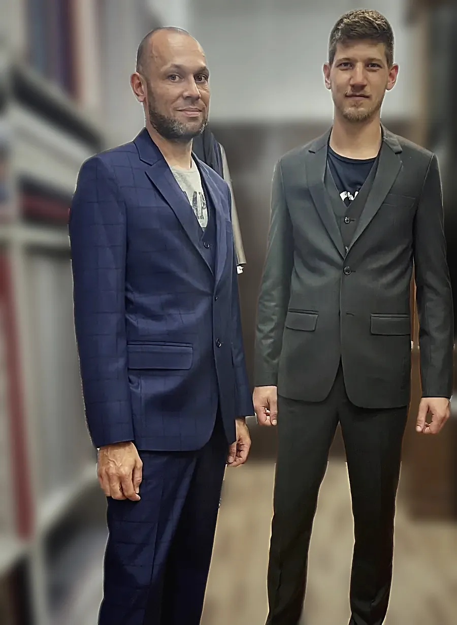 A navy windowpane three-piece and a dark grey three-piece, both waistcoated, at the fitting.
