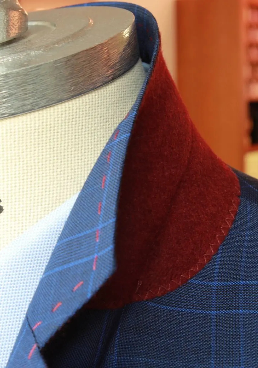 A burgundy melton undercollar set against blue check, felled by hand.