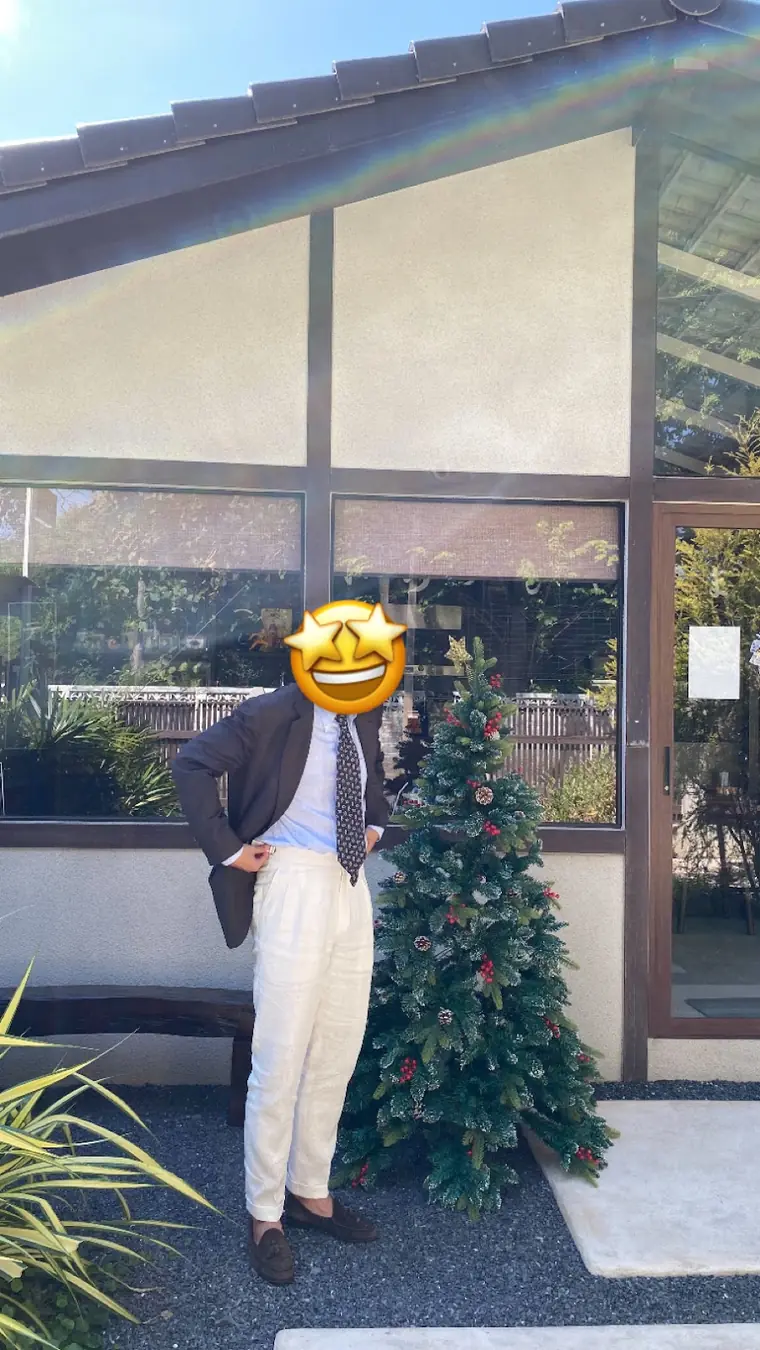The cream linen trousers the review praises, worn outdoors with a blue shirt, patterned tie and brown suede loafers. The reviewer covered their own face with a sticker.